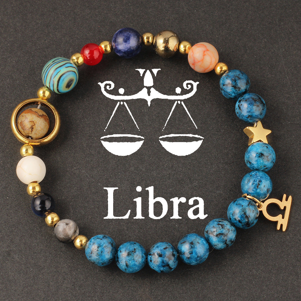 Natural zodiac stone bracelet hand-knotted with deep sea blue speckled beads and gold Aquarius charm, on clean white background.