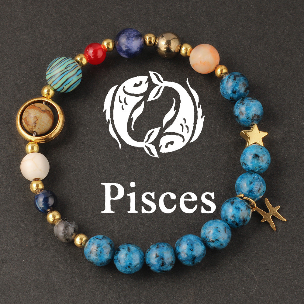 Natural zodiac stone bracelet worn on a slim wrist beside cream knit sleeve, soft daylight, casual autumn styling.