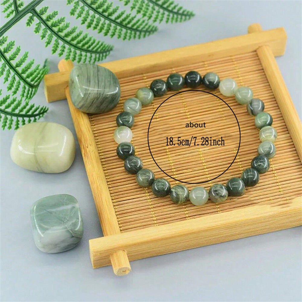 Natural Green Jade Cat Eye Bracelet resting on linen beside a small ceramic cup, styled as a quiet daily stacker for women who love green jade jewelry