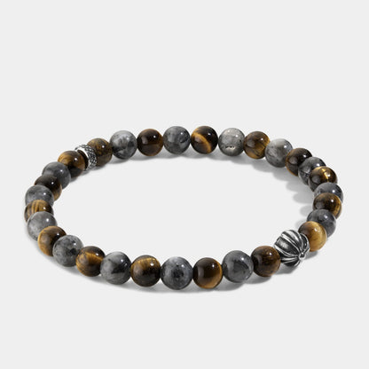 Close-up of natural tiger eye hawk eye stone bracelet showing polished round beads with chatoyant golden-brown tiger eye, blue-grey hawk eye natural stone surface and handcrafted silver accent beads, elastic structure.