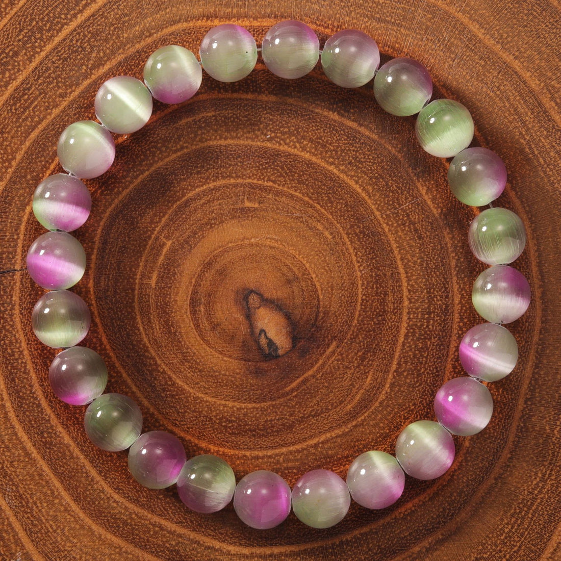 Natural cat eye stone bracelet showing 23 pink, green and ivory cat&