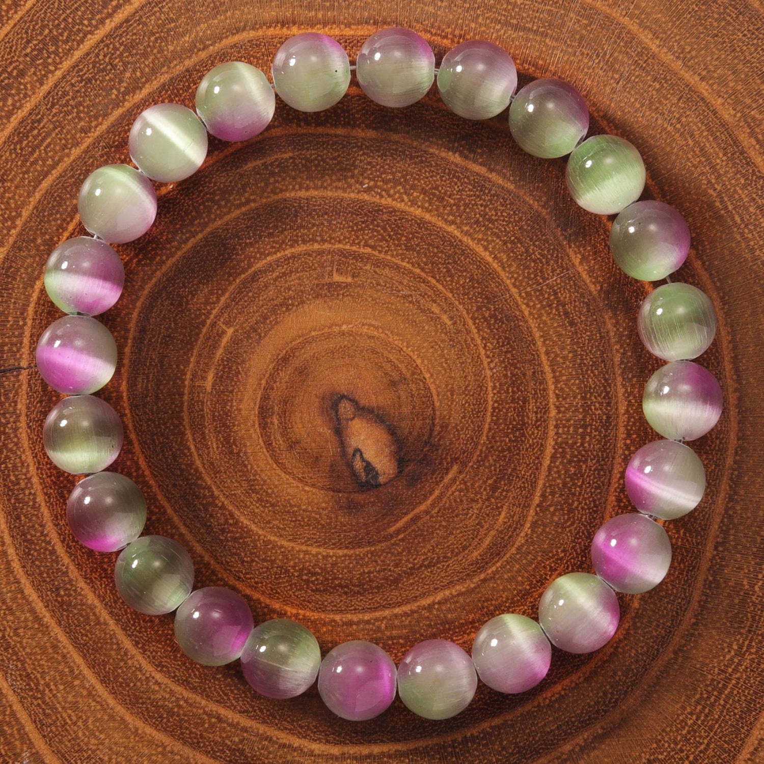 Natural cat eye stone bracelet showing 23 pink, green and ivory cat&