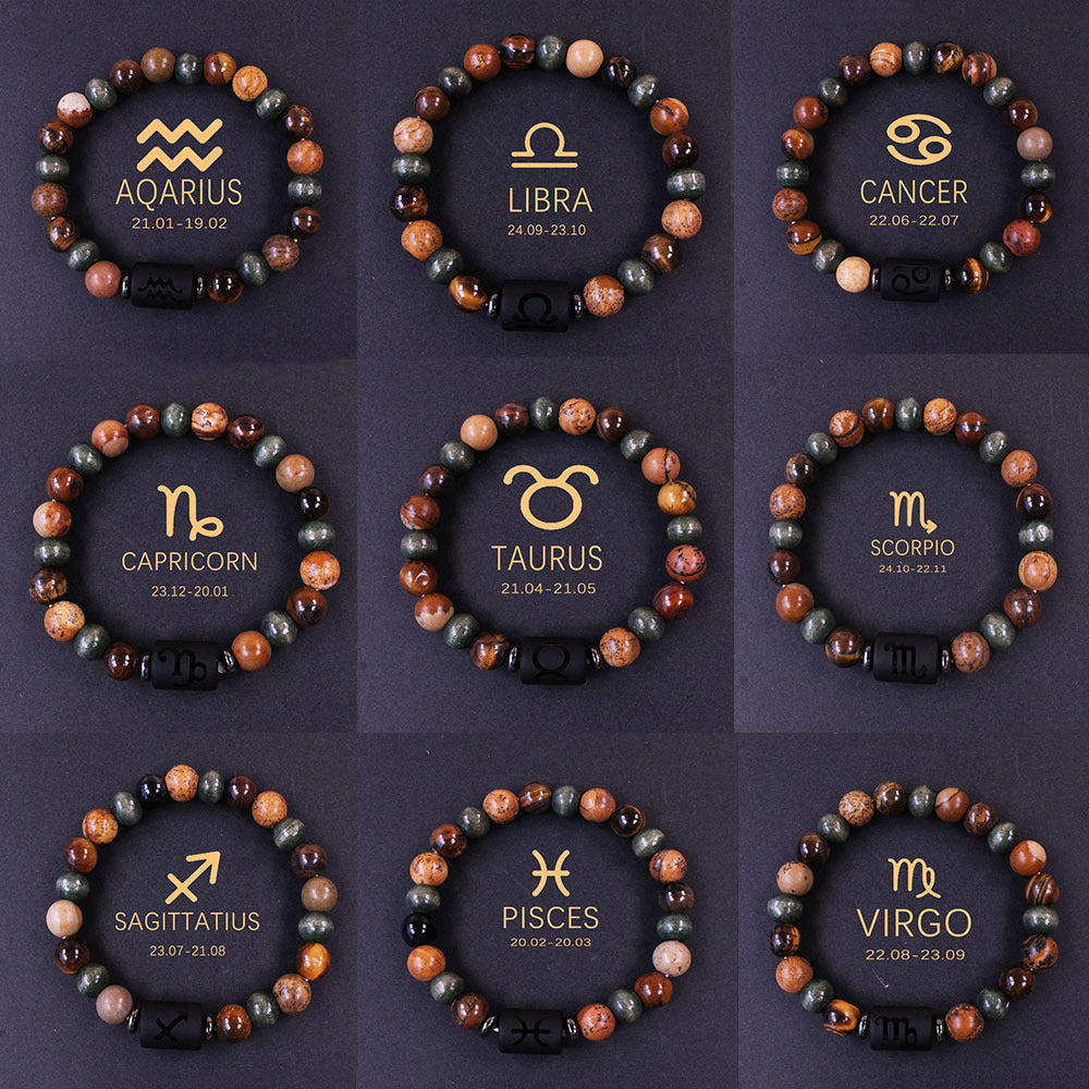 Natural zodiac stone bracelet showing three-color alternating beads — warm chatoyant tiger eye, blue-green hawk eye and dark agate — with engraved black obsidian zodiac symbol charm on elastic cord.