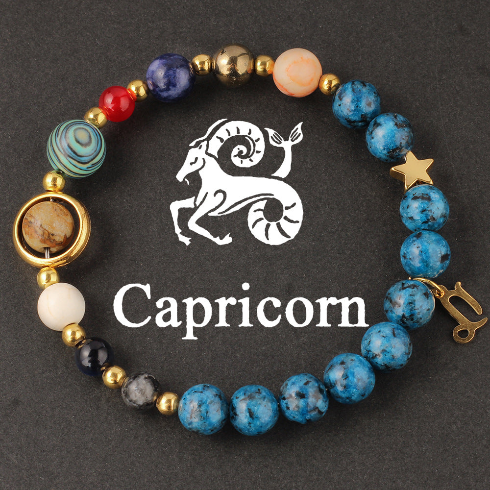 Close-up of Natural zodiac stone bracelet highlighting polished speckled blue beads, red jasper and cream accents on golden elastic strand.