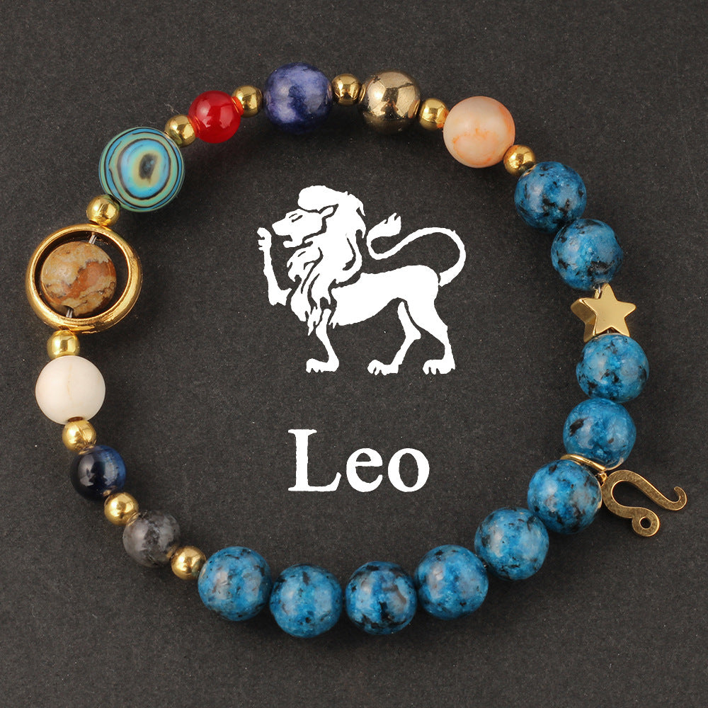 Close-up of Natural zodiac stone bracelet highlighting polished speckled blue beads, red jasper and cream accents on golden elastic strand.