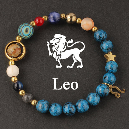 Close-up of Natural zodiac stone bracelet highlighting polished speckled blue beads, red jasper and cream accents on golden elastic strand.