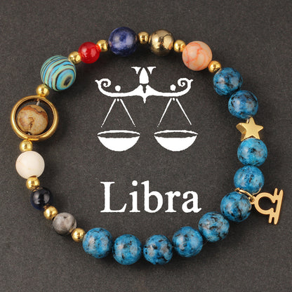 Natural zodiac stone bracelet hand-knotted with deep sea blue speckled beads and gold Aquarius charm, on clean white background.