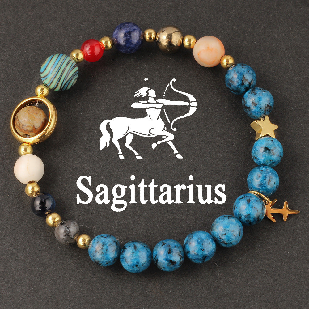 Natural zodiac stone bracelet worn on a slim wrist beside cream knit sleeve, soft daylight, casual autumn styling.