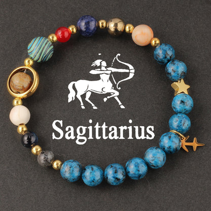 Natural zodiac stone bracelet worn on a slim wrist beside cream knit sleeve, soft daylight, casual autumn styling.