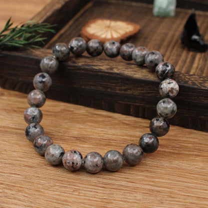 Natural Yooperlite Glow Stone Bracelet resting beside a small UV flashlight and a journal, styled as a quiet collectible daily piece for crystal lovers