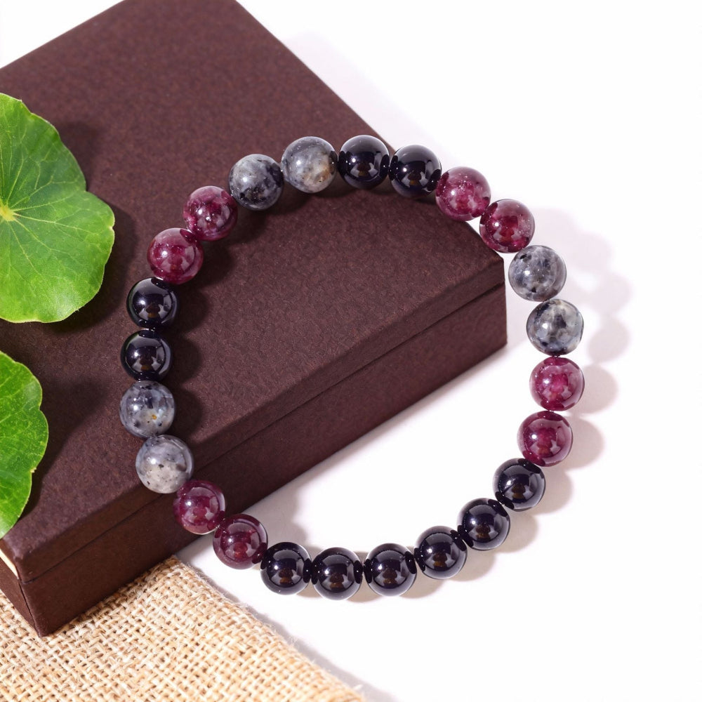 Natural Garnet Black Onyx Smoky Crystal Bracelet on a warm weathered wood surface, hand-strung with deep garnet red, smooth black onyx and translucent smoky beads
