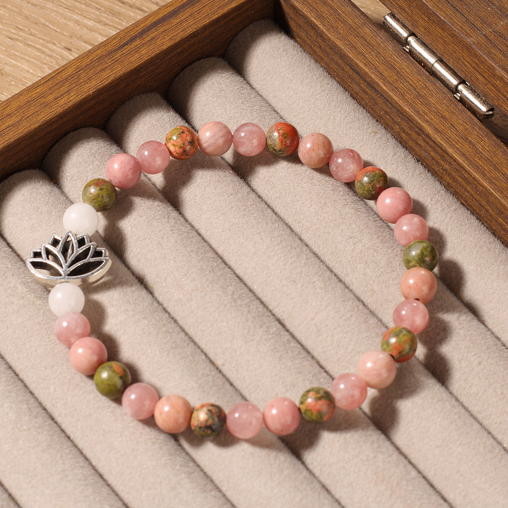Natural Pink Crystal Lotus Bracelet resting on linen beside a small journal and dried flowers, styled as a quiet daily stacker for women who love spiritual jewelry