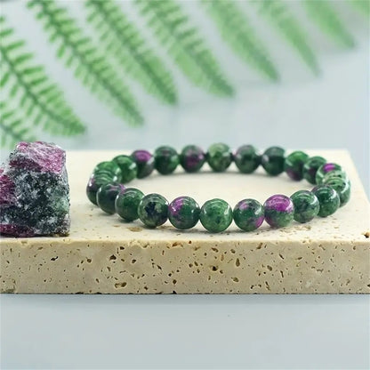  Close-up of Natural Green Zoisite Ruby Bracelet, focusing on the mossy green stone surface, deeper shadow streaks and tiny ruby-red flecks catching the light