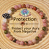 Natural Pink Crystal Lotus Bracelet on a warm wood plate, hand-strung with smooth rose-toned stone beads and a small silver lotus charm resting against the wrist