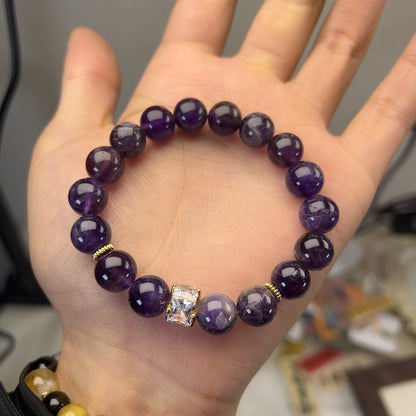 Natural amethyst bracelet resting on linen beside a journal and dried lavender sprig, soft morning daylight, calm meditation ritual still life, healing crystal jewelry for women.
```