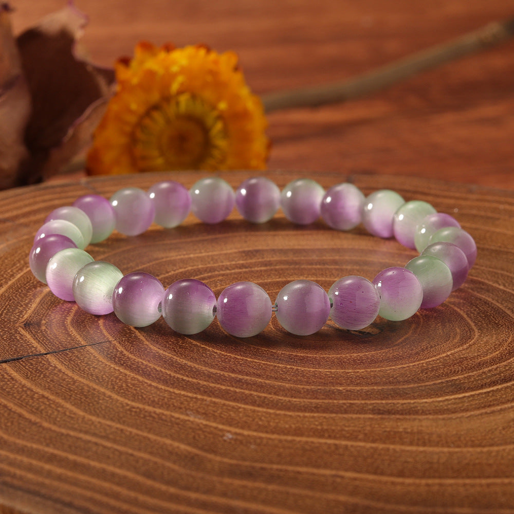 Natural cat eye stone bracelet resting on linen beside a journal and dried flowers, soft daylight, calm everyday ritual atmosphere, handcrafted crystal jewelry for women.