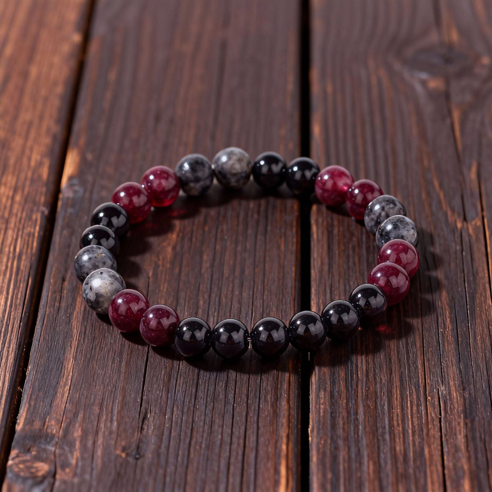Close-up of Natural Garnet Black Onyx Smoky Crystal Bracelet, focusing on the trio of garnet red, black onyx and smoky inclusion beads sitting side by side
