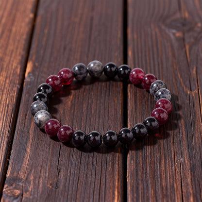 Close-up of Natural Garnet Black Onyx Smoky Crystal Bracelet, focusing on the trio of garnet red, black onyx and smoky inclusion beads sitting side by side