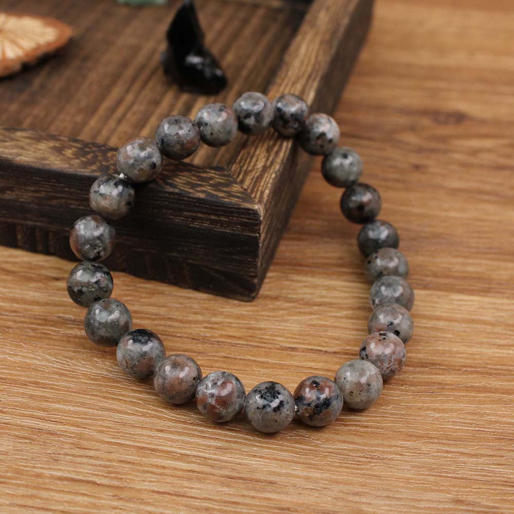 Natural Yooperlite Glow Stone Bracelet shown from a second angle, emphasizing the soft stretch cord loop and the speckled syenite pattern across the circle