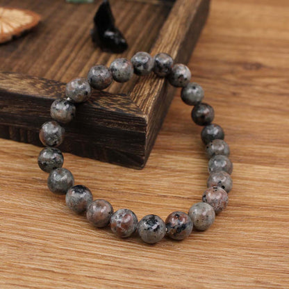 Natural Yooperlite Glow Stone Bracelet shown from a second angle, emphasizing the soft stretch cord loop and the speckled syenite pattern across the circle