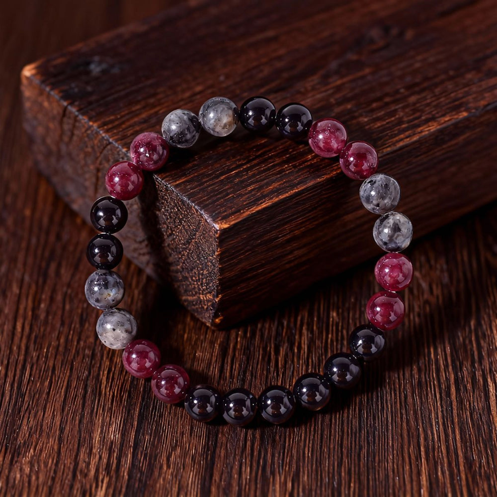 Close-up of Natural Garnet Black Onyx Smoky Crystal Bracelet, focusing on the trio of garnet red, black onyx and smoky inclusion beads sitting side by side